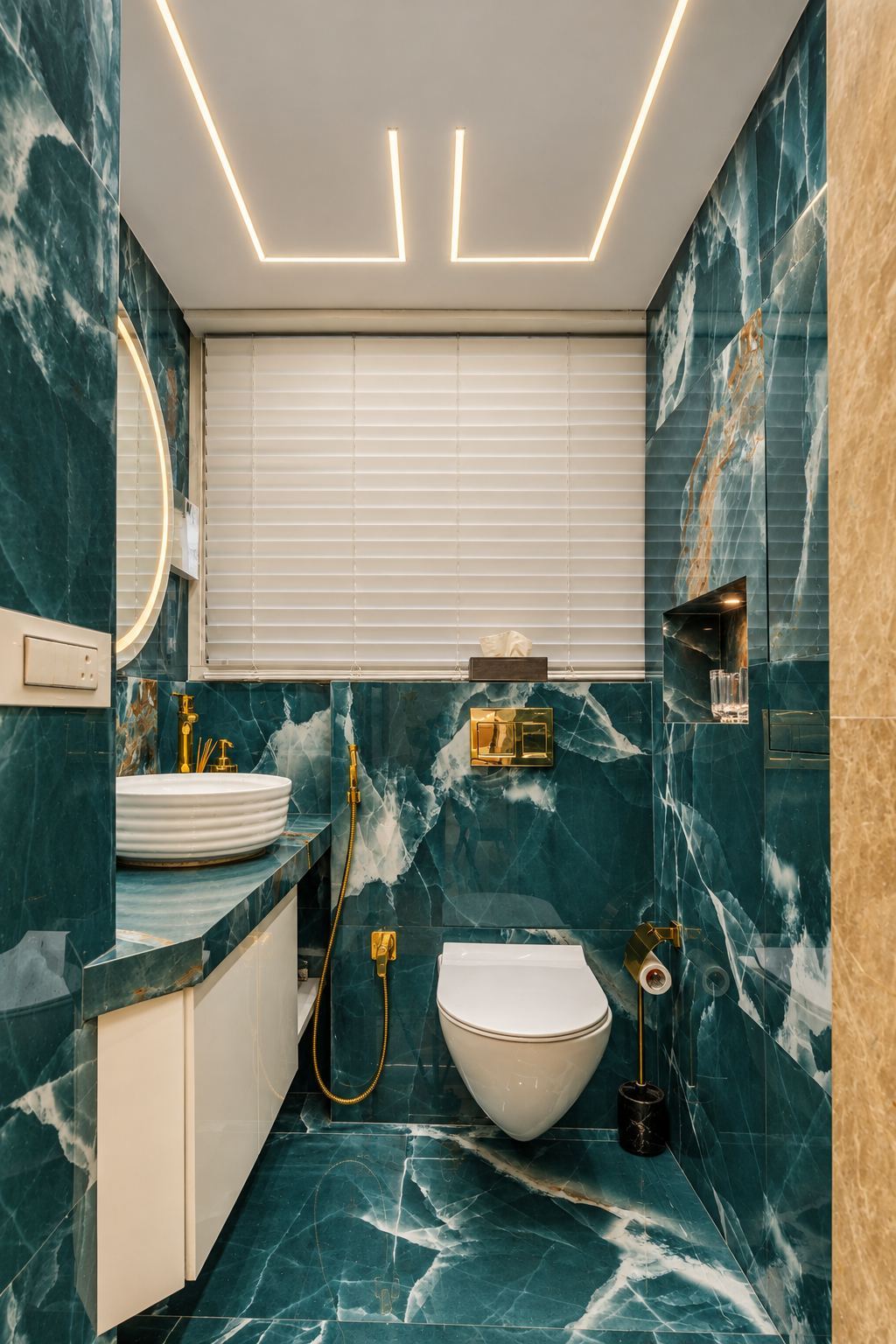 Powder room in deep teal marble with gold fittings