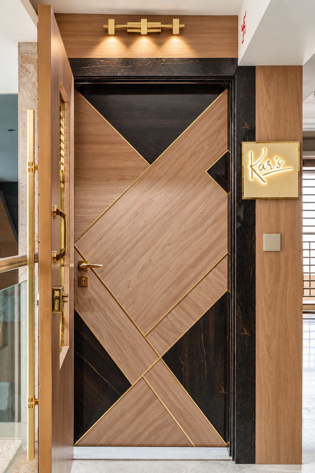 Main door in walnut and dark veneer with brass inlay and brass lights
