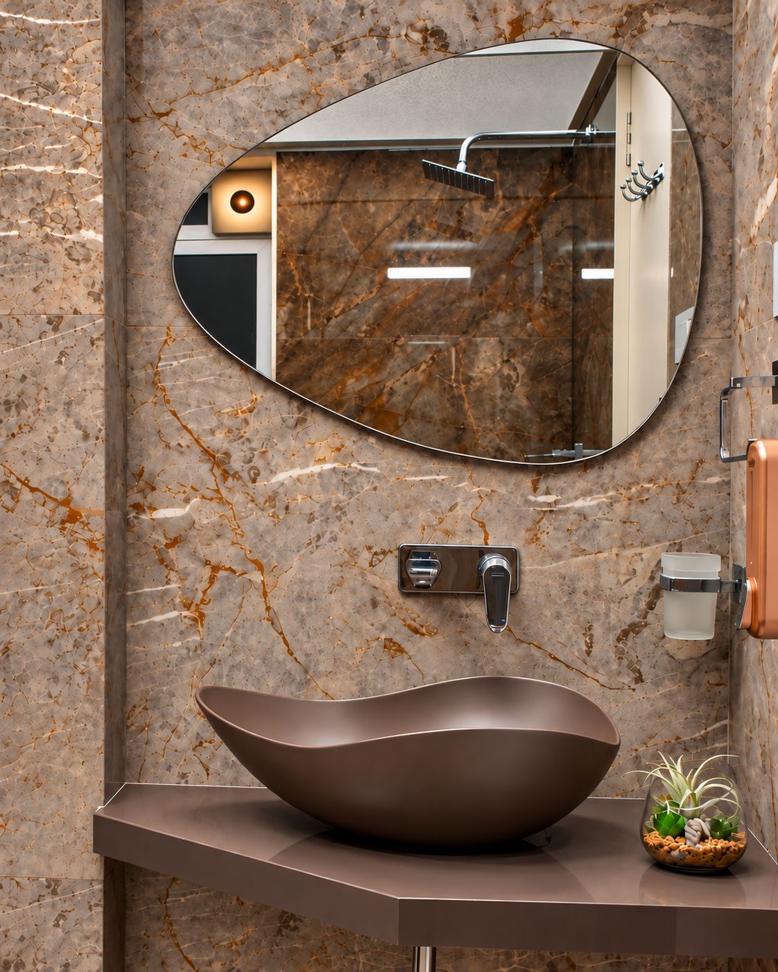 Vanity with a pebble-shaped mirror and a vessel basin on veined marble