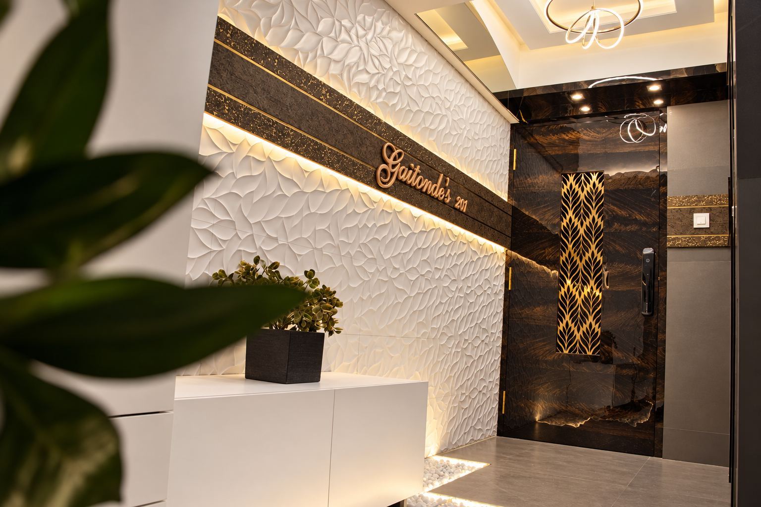Foyer with a sculpted white wall panel and a dark main door with a brass tree grille